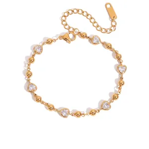 Detailansicht eines vergoldeten Armbands mit Herzkristallen und Goldperlen.