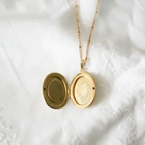 Detailansicht eines vintage 14k Gold Medaillon Halskette auf weißem Spitzenstoff