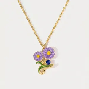 Elegant gold chain necklace with purple enamel birth flowers and a blue sapphire gemstone