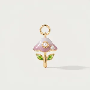 Close-up detail showing the intricate enamel work and pearl on the mushroom charm
