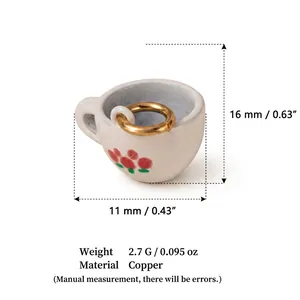Gros plan d'un pendentif tasse en céramique miniature avec anneau en cuivre doré et mesures