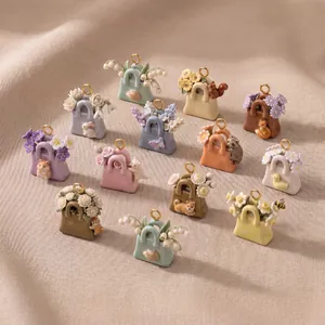 Collezione di ciondoli a borsa con animali colorati e dettagli floreali su tessuto beige