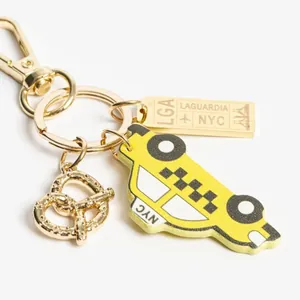New York City themed keychain with yellow taxi charm and golden pretzel accessory