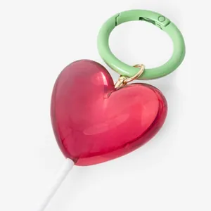 Sweet translucent red heart-shaped bag charm with a mint green circular carabiner clip.