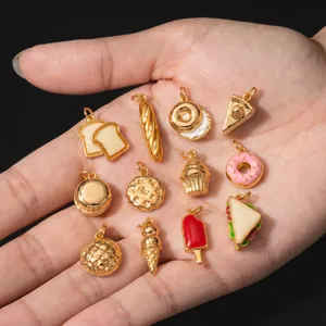 Collezione di vari ciondoli alimentari in acciaio inossidabile placcati oro 18K in mano