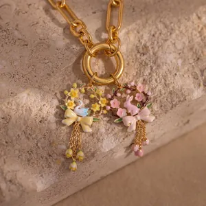 Detail of enamel floral wreath pendants featuring a white swan and a pink bunny.