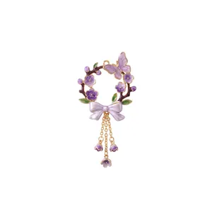 Detailed view of lavender floral wreath pendant with purple butterfly and gold chain tassels