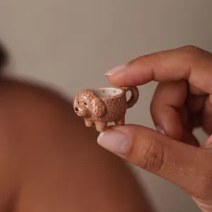 Macro view showing the intricate texture and tiny size of this poodle teacup pendant.