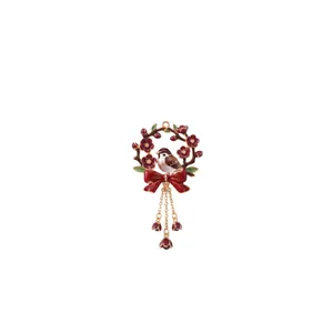 Exquisite enamel floral wreath pendant featuring a bird, red bow, and tassel chains