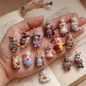 Variété de charms animaux peints à la main en émail, présentés dans la paume de main