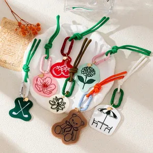 Niche design acrylic bag charms featuring lotus and bear motifs with colorful ropes