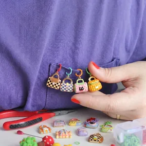 Macro view of colorful mini enamel handbag charms with checkered patterns for DIY jewelry