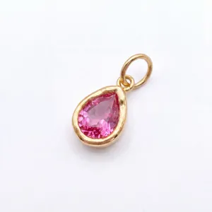 Gedetailleerde opname van een peervormige roze edelsteenhanger in een goudkleurige kast.