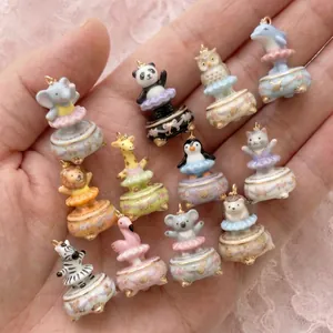 Detailed view of various cute ballet animal charms with tutu skirts and gold accents.