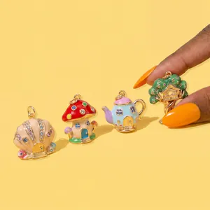 Close-up of colorful enamel fairy house charms featuring shell, mushroom, and teapot designs