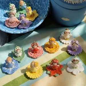 Vista dettagliata di ciondoli fata dei fiori in ceramica dipinti a mano con basi floreali