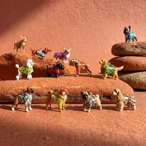 Detail view of various colorful enamel leopard dog charms displayed on natural stones
