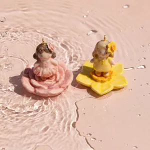 Dettaglio macro di ciondoli a forma di fata dei fiori in ceramica nell'acqua