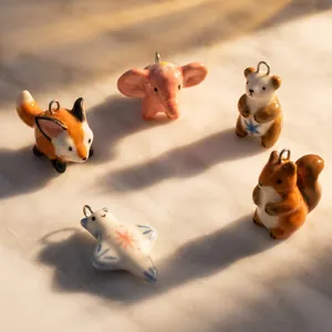 Vue détaillée de cinq pendentifs animaux en céramique peints à la main