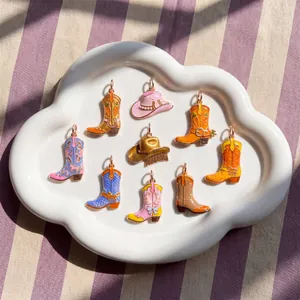 Colorful enamel cowboy boot and hat charms arranged on a white decorative plate