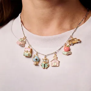 Detailed macro shot of colorful school-themed enamel charms on a silver link necklace