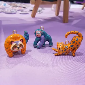 Detailed view of colorful hand-painted animal charms including raccoon, monkey and leopard shapes