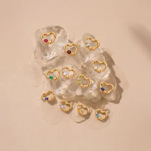 Collezione di dodici ciondoli a cuore in oro con pietre portafortuna su cubetti di ghiaccio