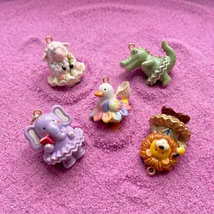 Vue détaillée de breloques d'animaux ballerines colorées sur un fond texturé rose