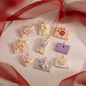 Detailed view of French style enamel envelope pendants with floral tulip and lavender designs.