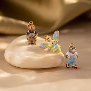 Close-up of colorful enamel animal charms: a beaver, fairy bee, and mole on skates