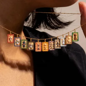 Dettaglio di una collana dorata con ciondoli da poker e simpatici gatti e cani