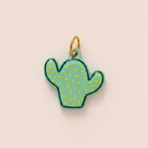 Detailed close-up showing a green enamel cactus pendant with vibrant yellow dots