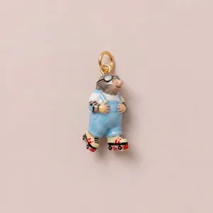 Macro detail of a hand-painted mole charm wearing goggles and roller skates on pink background