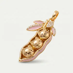Detail shot of golden pea pod pendant with three cute cats and pink enamel details.
