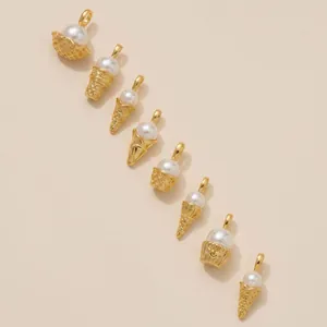 Detail of various gold ice cream and cupcake pendants with pearls for jewelry DIY making