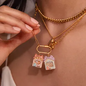 Detailed view of fairy tale house pendants with fox and rabbit motifs on gold chains