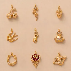 Collection détaillée de neuf charms de luxe en acier titane doré avec des pierres pavées