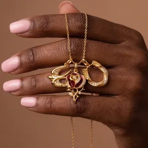 Gros plan détaillé d'un pendentif rose dorée avec diamants et finition en émail rouge