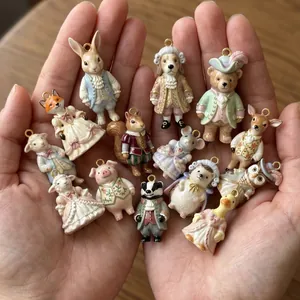 Detailed view of cute porcelain animal charms in Victorian outfits held in cupped hands