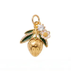 Close-up of a golden strawberry pendant featuring green enamel leaves and sparkling crystals.