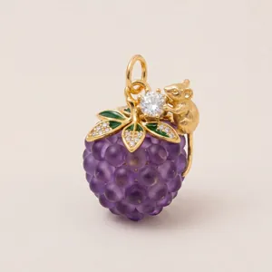 Detailed macro view of a luxury enamel grape pendant featuring a golden mouse and crystals