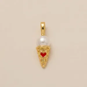 Detail shot of a gold-plated ice cream cone pendant with a white pearl and red heart.