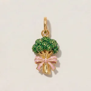 High-quality detail of a gold-plated enamel broccoli pendant with a cute pink bow decoration.