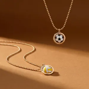 Détail des pendentifs rotatifs de football et de beach-volley sur chaînes dorées à boules