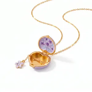 Detail view of an open purple enamel heart locket necklace with floral interior pattern