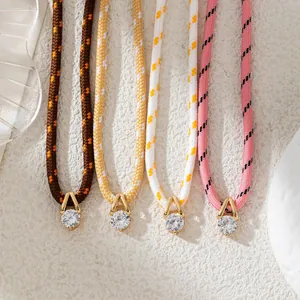 Detailed view of four colorful braided rope necklaces with sparkling zirconia pendants.