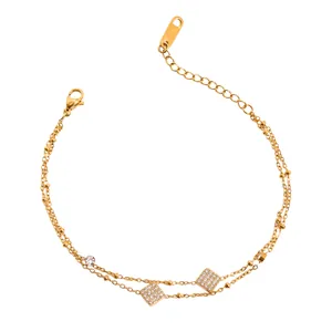 Macro detail of double-layer gold-plated titanium steel bracelet with zircon charms.
