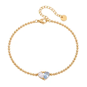 Close-up of gold bead bracelet with sparkling white and blue heart-shaped zircon stones.