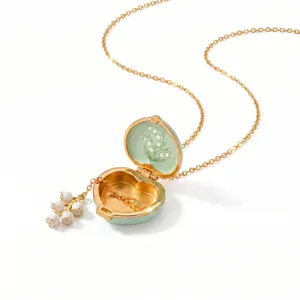 Close-up view of heart-shaped enamel locket necklace with lily of the valley design