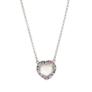Dettaglio del ciondolo a cuore con piccoli strass colorati su una sottile collana